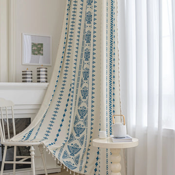 Cream curtain with vertical blue geometric and tribal-inspired patterns.