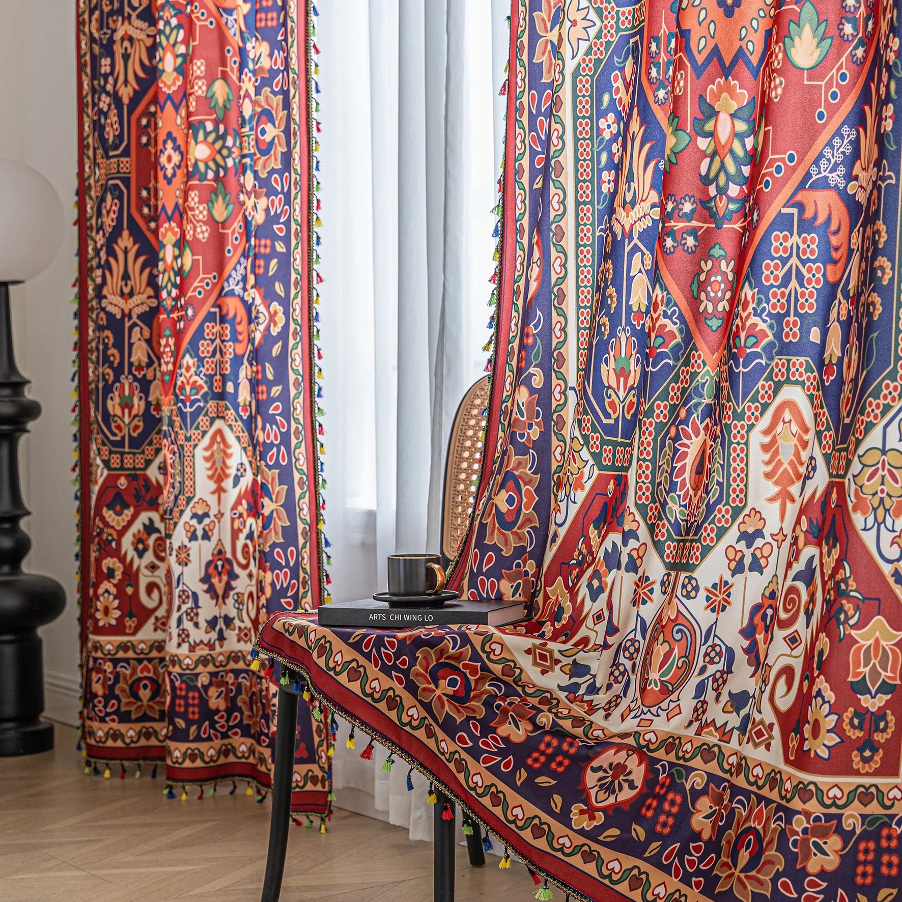 Eye-catching curtain showcasing a rich blend of red, navy, and cream tones with intricate floral and geometric motifs, finished with colorful tassel edging — ideal for creating a warm, artistic, and culturally inspired home ambiance.slider_item_LCniFL