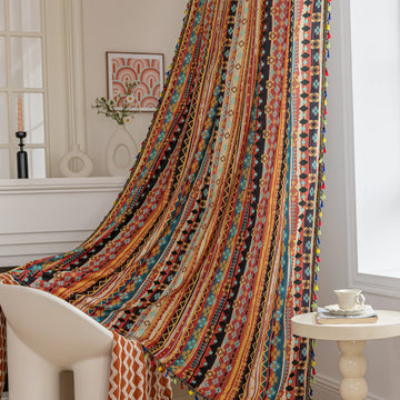 A vibrant curtain with a striking pattern of colorful stripes, featuring geometric shapes in red, orange, yellow, blue, and black. The curtain is adorned with playful tassels along the edges, adding a lively touch to the space.