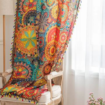 A colorful bohemian curtain with vibrant circular patterns in red, brown, blue, and yellow, decorated with multicolor tassels and braided trim, adding an artistic and lively touch to home d¨¦cor.