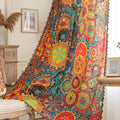A colorful bohemian curtain with vibrant circular patterns in red, brown, blue, and yellow, decorated with multicolor tassels and braided trim, adding an artistic and lively touch to home décor.