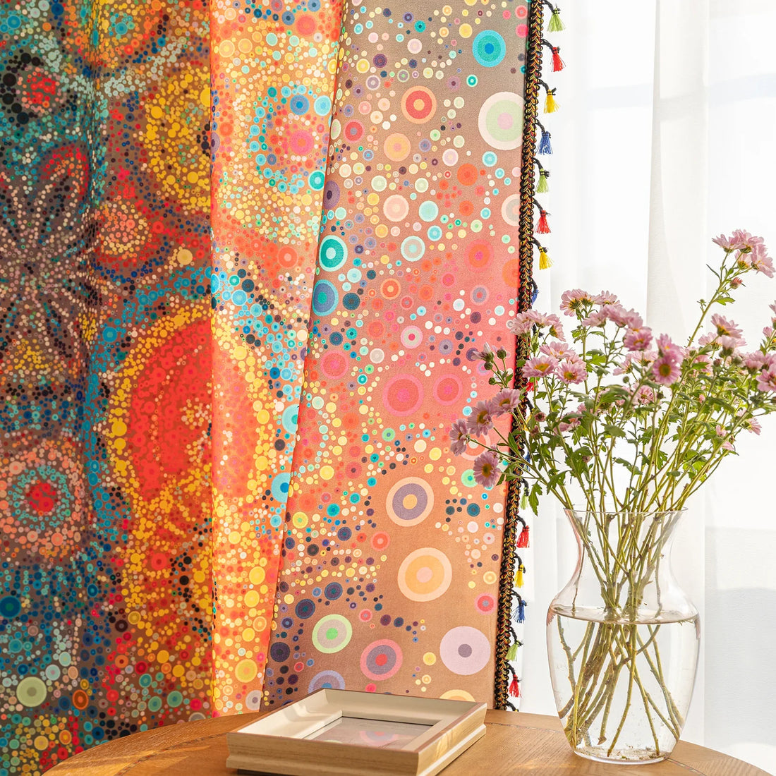 A colorful bohemian curtain with vibrant circular patterns in red, brown, blue, and yellow, decorated with multicolor tassels and braided trim, adding an artistic and lively touch to home décor.