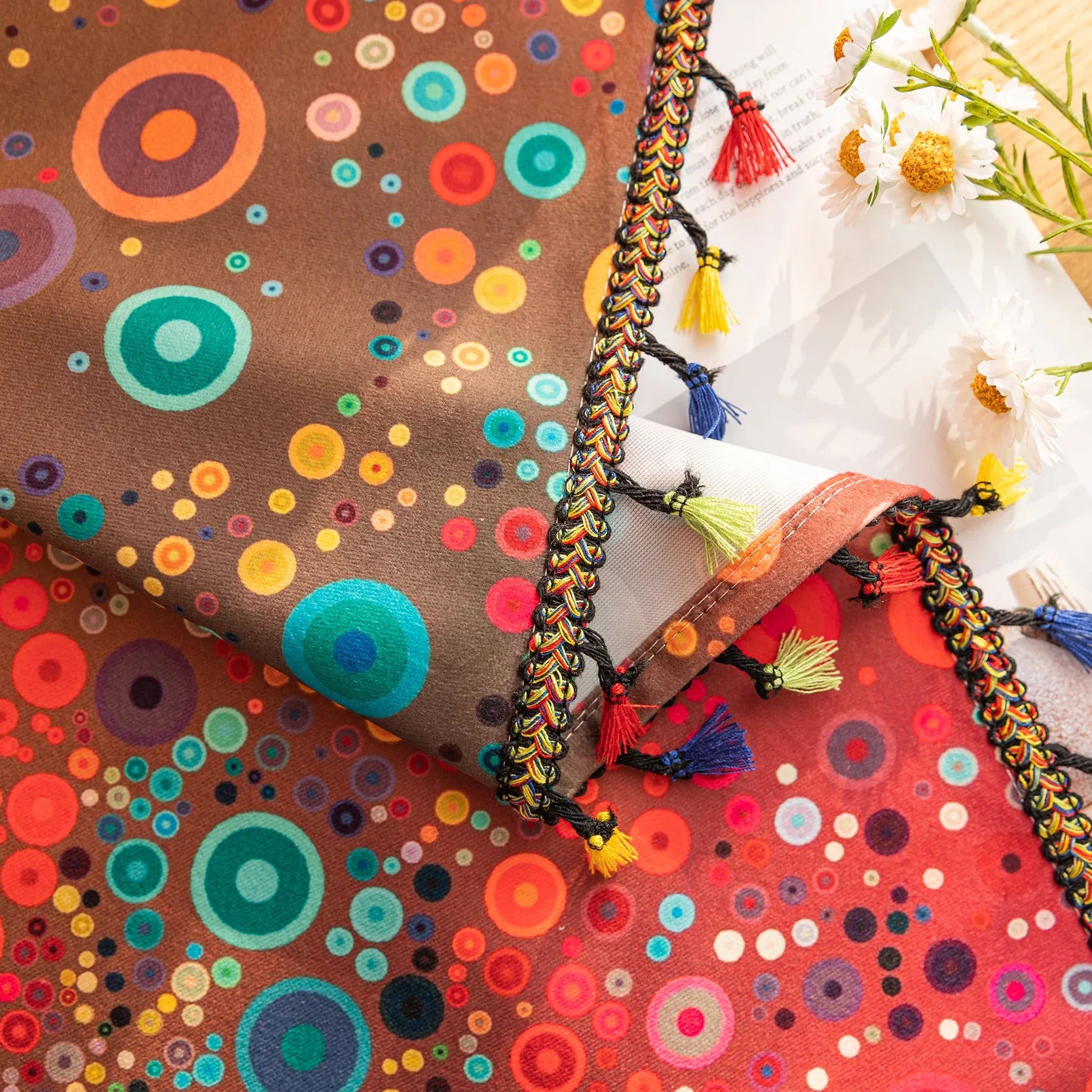 Close-up of a colorful bohemian curtain with vibrant circular patterns in red, brown, blue, and yellow, decorated with multicolor tassels and braided trim, adding an artistic and lively touch to home décor.