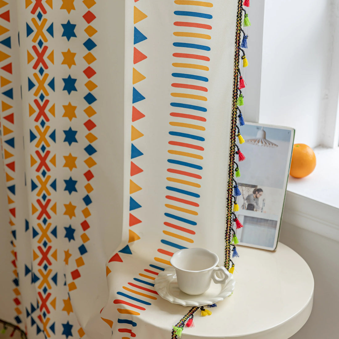White curtain with colorful geometric patterns in red, yellow, and blue, featuring stripes, triangles, and star motifs, adding a vibrant and modern touch to living room or bedroom decor.