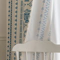 Cream curtain with vertical blue geometric and tribal-inspired patterns.