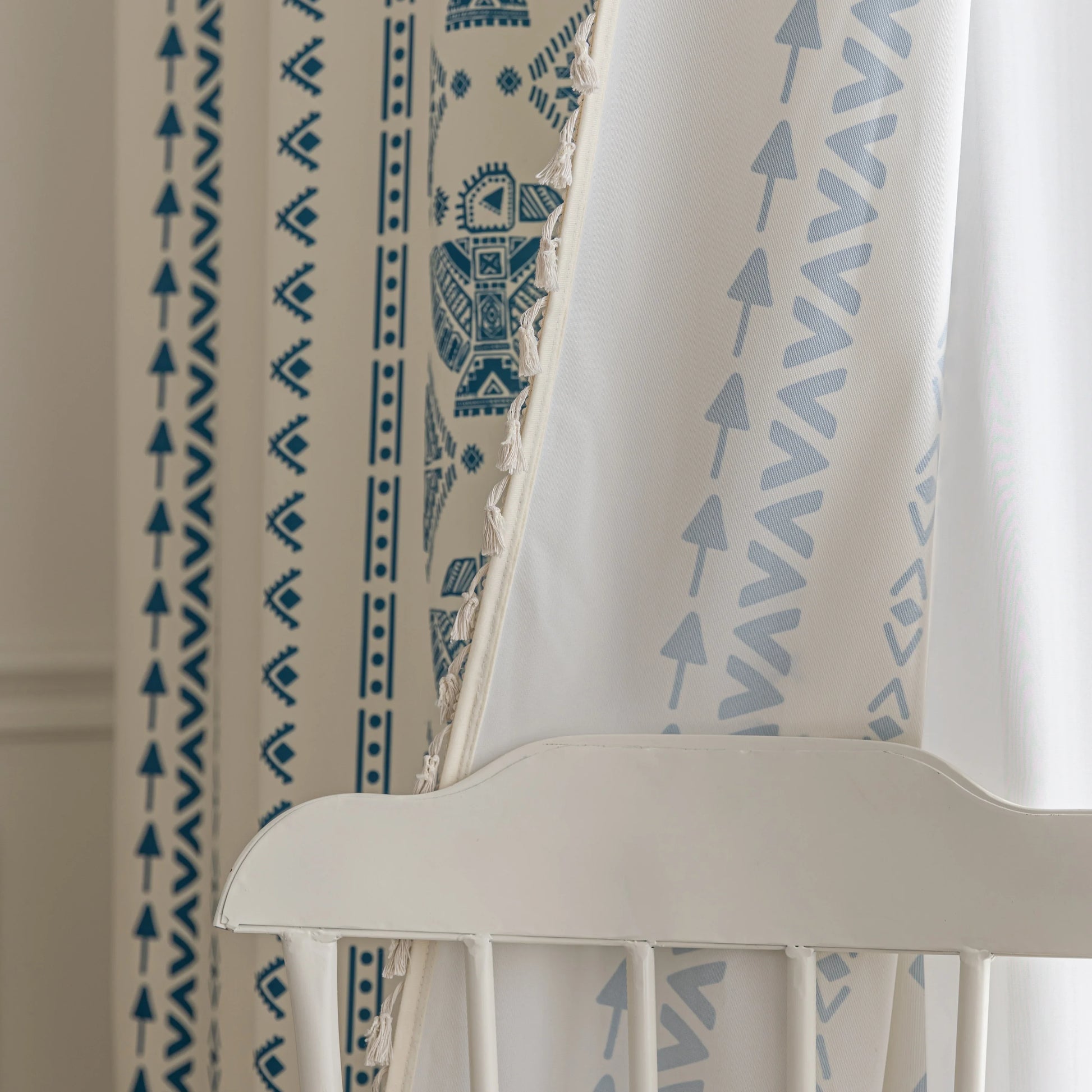 Cream curtain with vertical blue geometric and tribal-inspired patterns.