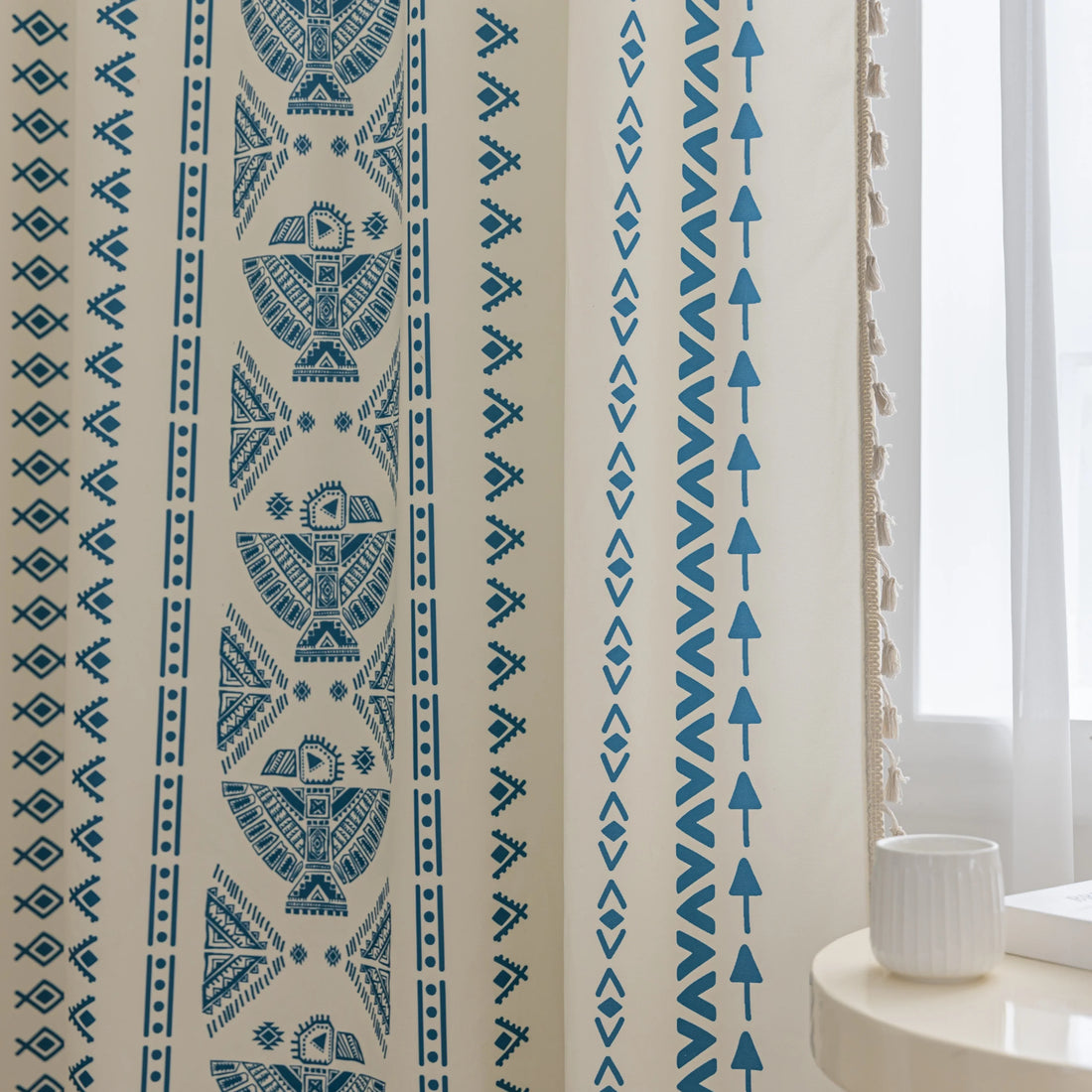 Cream curtain with vertical blue geometric and tribal-inspired patterns.