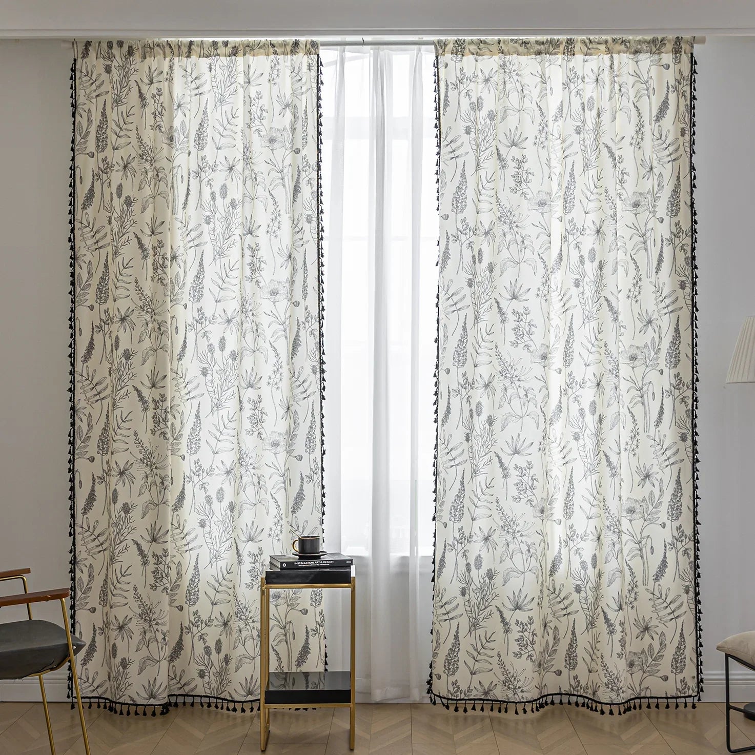 Cream curtains with black botanical print and black tassel trim.