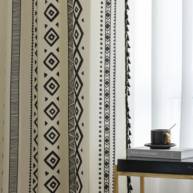 Close-up of cream curtain with bold black vertical tribal and geometric patterns, adding a modern bohemian touch to interior decor.