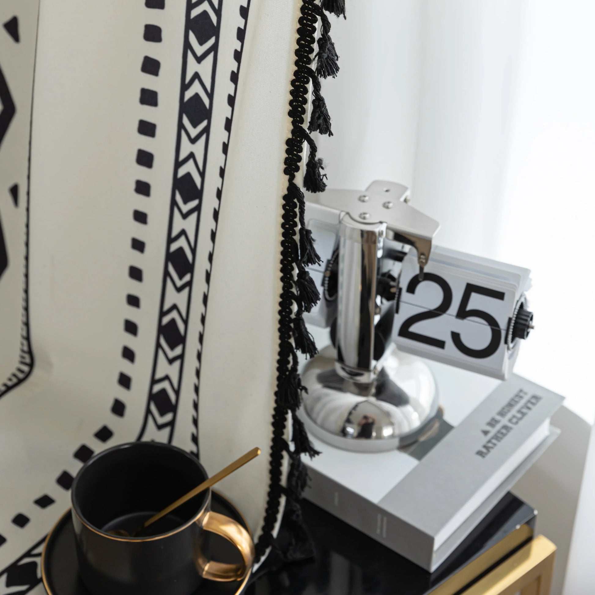 Close-up of cream curtain with bold black vertical tribal and geometric patterns, adding a modern bohemian touch to interior decor.