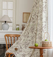 Beige curtain with bird and botanical print in brown and green, featuring decorative tassel trim for a rustic, nature-inspired look.