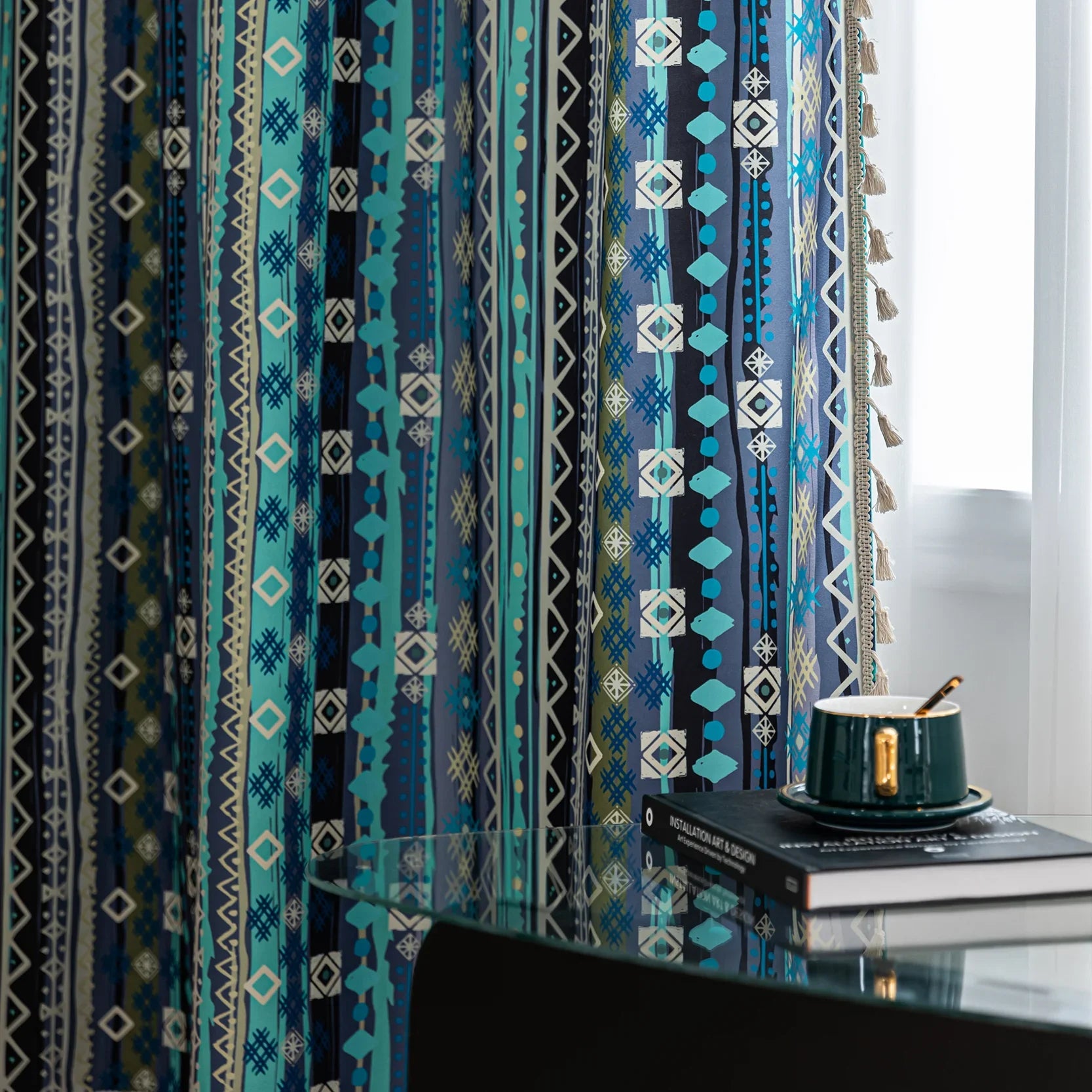 Blue geometric patterned curtain with tribal-inspired design, featuring white tassel trim for a bold and decorative accent.