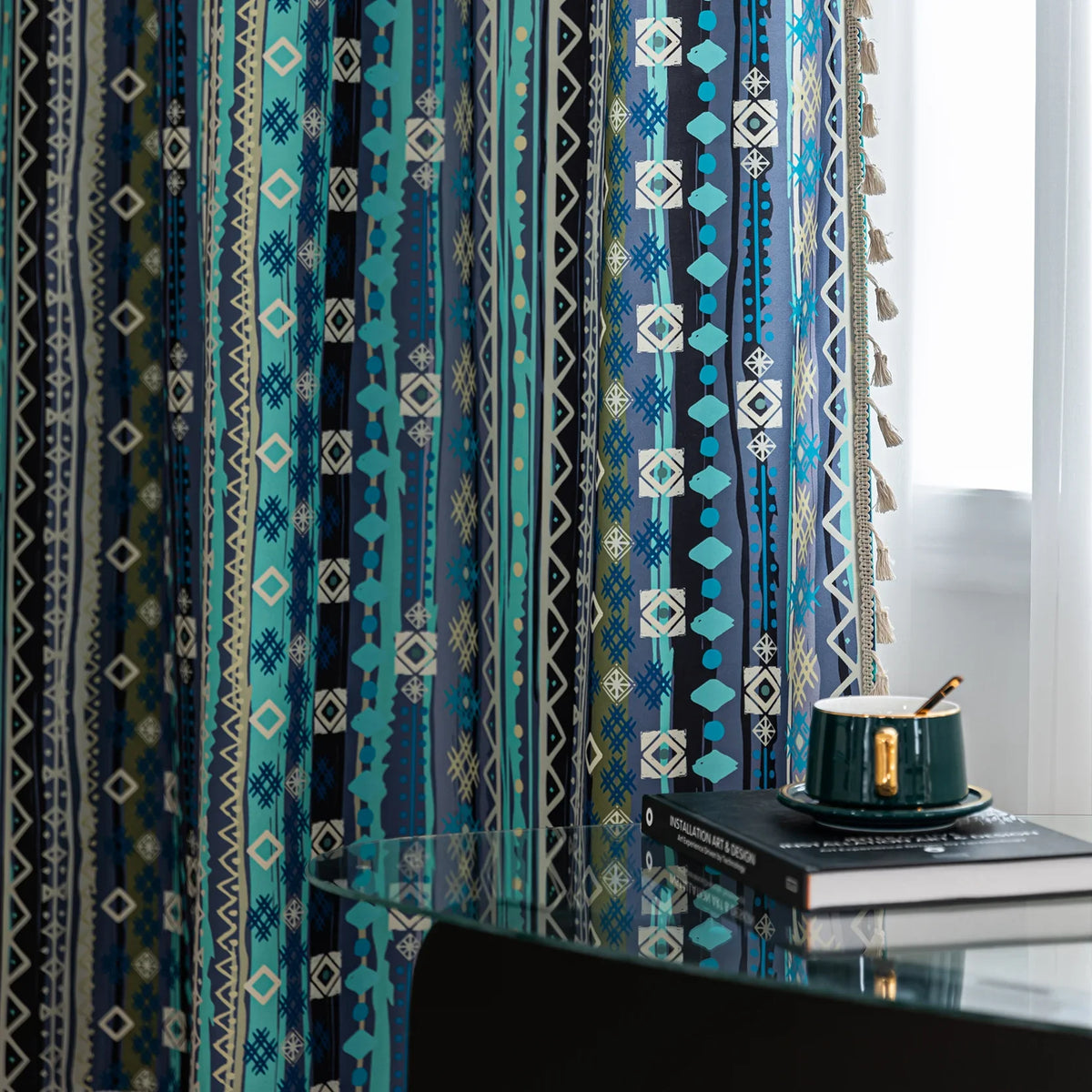 Blue geometric patterned curtain with tribal-inspired design, featuring white tassel trim for a bold and decorative accent.