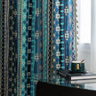 Blue geometric patterned curtain with tribal-inspired design, featuring white tassel trim for a bold and decorative accent.