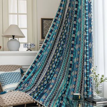 Blue geometric patterned curtain with tribal-inspired design, featuring white tassel trim for a bold and decorative accent.