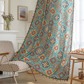 Colorful bohemian-style curtain with intricate geometric and floral patterns in turquoise, red, yellow, and navy, adding a vibrant touch to living room décor.