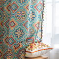 Colorful bohemian-style curtain with intricate geometric and floral patterns in turquoise, red, yellow, and navy, adding a vibrant touch to living room décor.