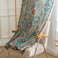 Colorful bohemian-style curtain with intricate geometric and floral patterns in turquoise, red, yellow, and navy, adding a vibrant touch to living room décor.