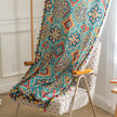 Colorful bohemian-style curtain with intricate geometric and floral patterns in turquoise, red, yellow, and navy, adding a vibrant touch to living room d¨¦cor.