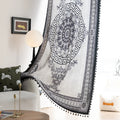 Black and white curtain fabric with Greek key pattern and floral accents, featuring decorative black tassel trim for a bold and elegant home décor style.