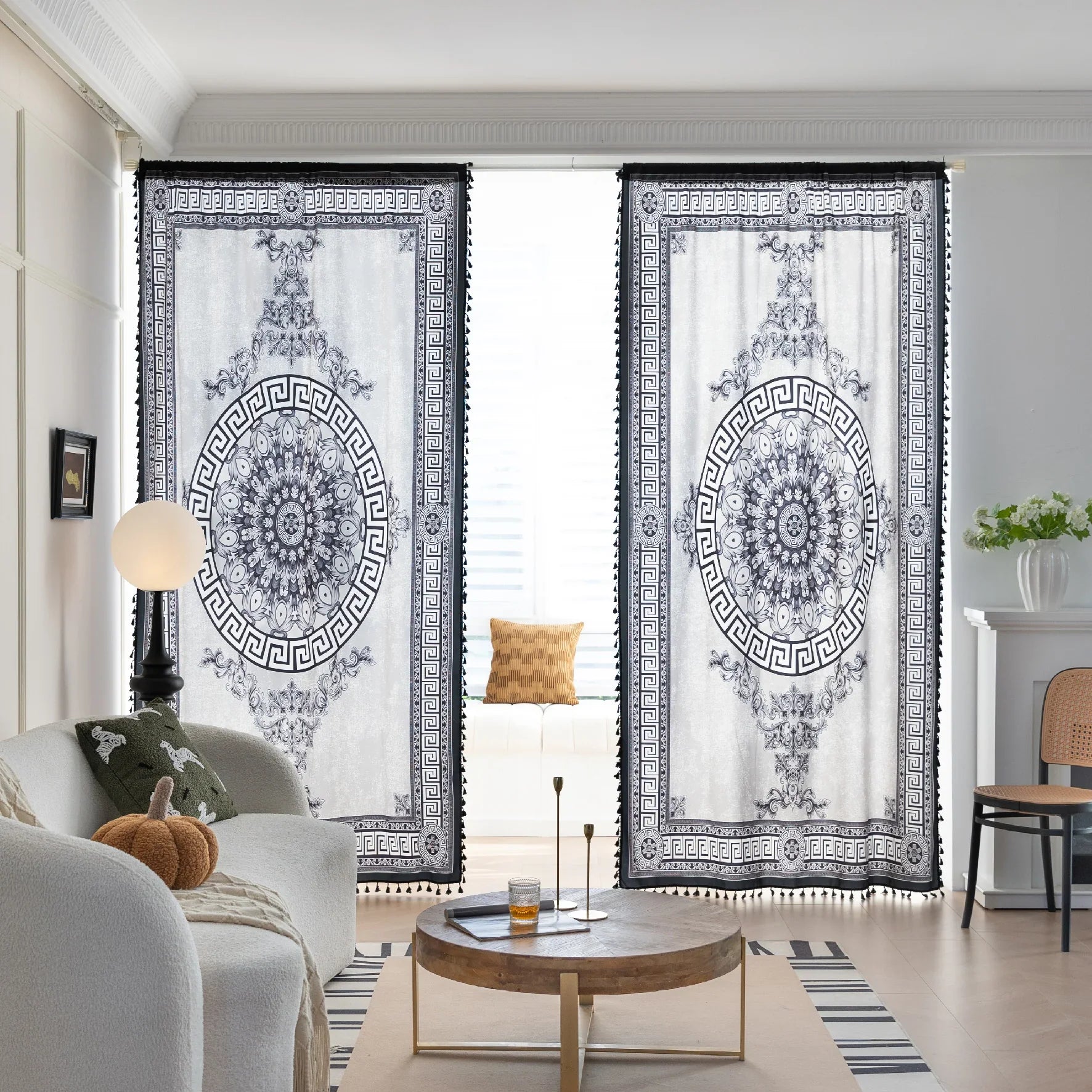 Black and white curtain fabric with Greek key pattern and floral accents, featuring decorative black tassel trim for a bold and elegant home décor style.