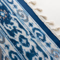 Blue and white curtain fabric with abstract watercolor-style pattern, accented by solid blue border and decorative white tassel trim for a coastal and artistic home décor look.
