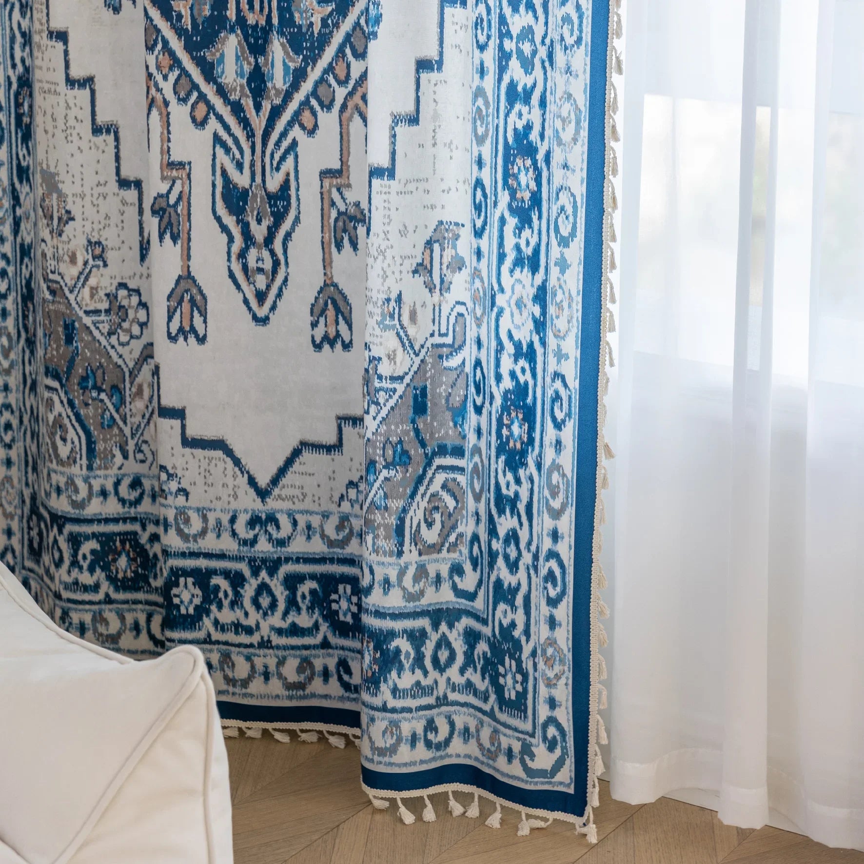 Blue and white curtain fabric with abstract watercolor-style pattern, accented by solid blue border and decorative white tassel trim for a coastal and artistic home décor look.
