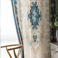 Close-up of an elegant curtain with intricate floral and medallion design in teal, beige, and gold tones, featuring ornate scrolling patterns for a classic and luxurious home décor look.