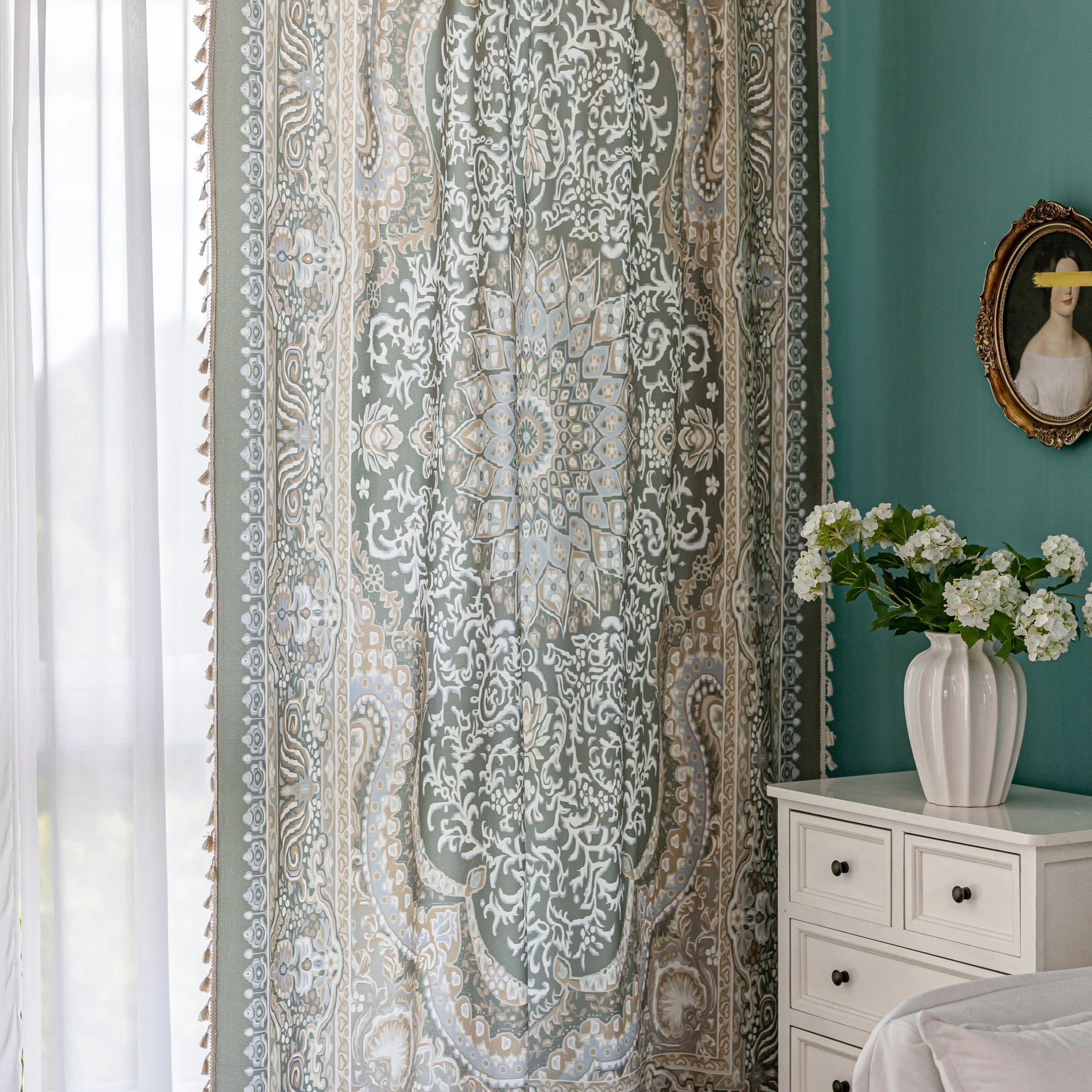 Close-up of an ornate curtain featuring a green background with intricate white floral and medallion patterns, accented with beige and gold details for a vintage, luxurious home décor style.