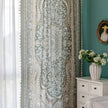 Close-up of an ornate curtain featuring a green background with intricate white floral and medallion patterns, accented with beige and gold details for a vintage, luxurious home d¨¦cor style.