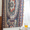 Colorful bohemian curtain with intricate floral and medallion patterns in navy blue, red, green, and cream, adorned with multicolored tassels.