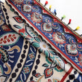 Colorful bohemian curtain with intricate floral and medallion patterns in navy blue, red, green, and cream, adorned with multicolored tassels.