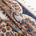 Close-up of a luxurious Persian-inspired curtain fabric featuring intricate floral and paisley patterns in navy blue, gold, and rust tones, accented with fine woven details and decorative tassel edging.