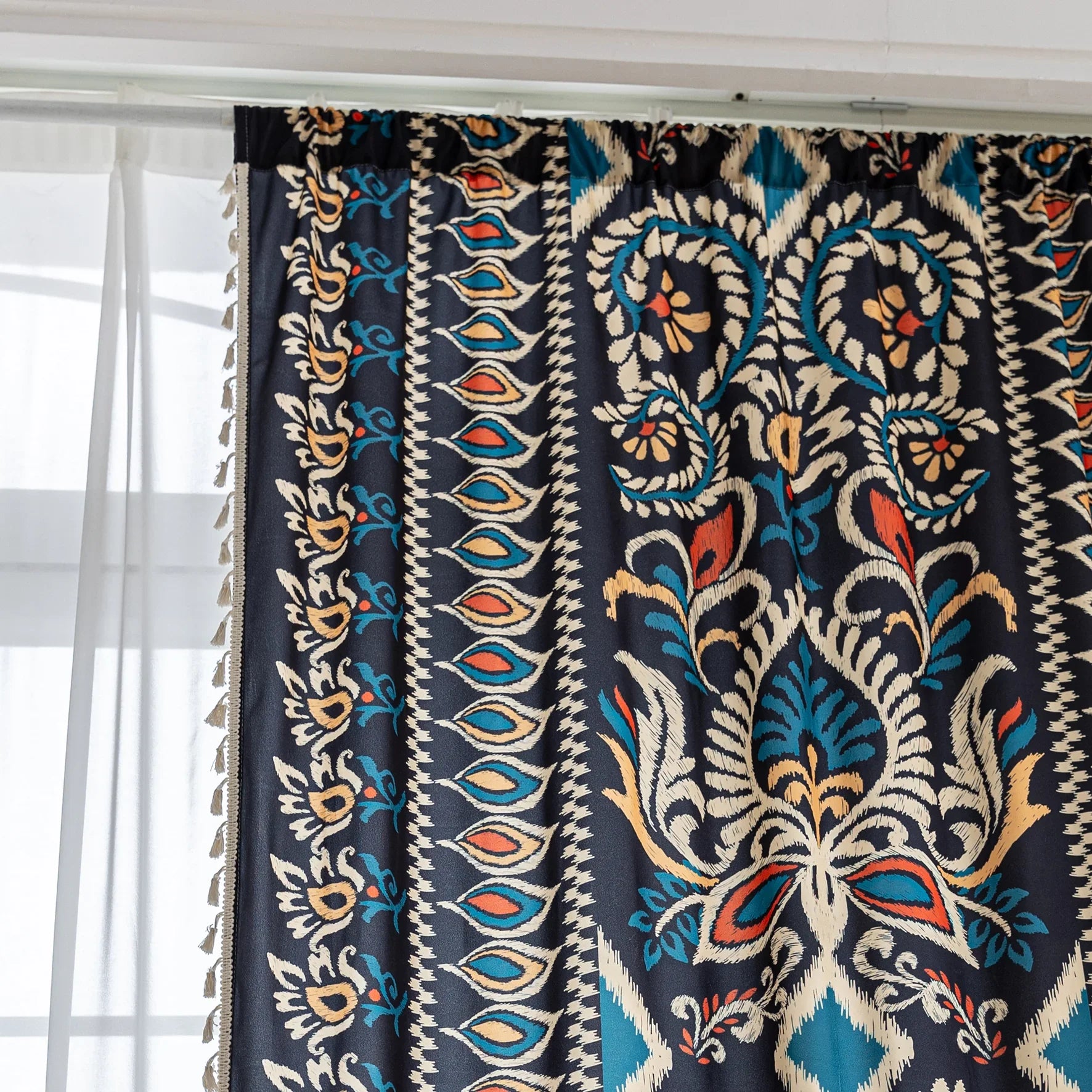 Luxurious bohemian-style curtain featuring a bold black base with intricate beige, red, and teal floral and geometric patterns, finished with elegant tassel trim — perfect for adding vibrant charm and cultural flair to your home décor.