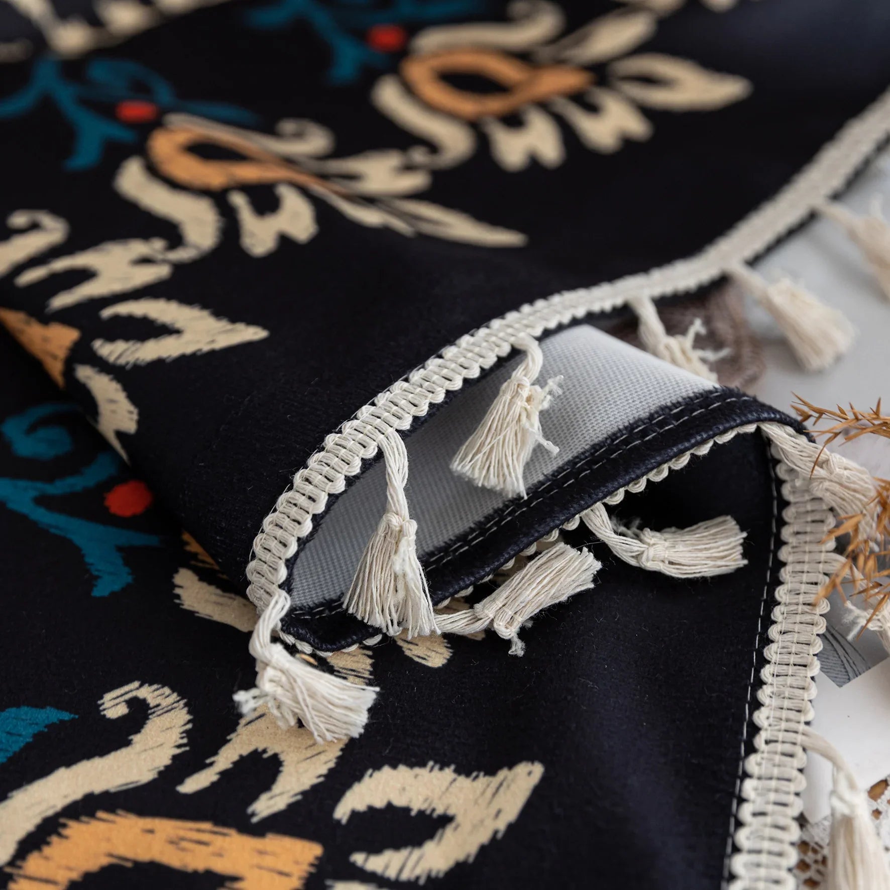 Luxurious bohemian-style curtain featuring a bold black base with intricate beige, red, and teal floral and geometric patterns, finished with elegant tassel trim — perfect for adding vibrant charm and cultural flair to your home décor.