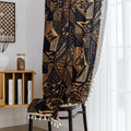 Stylish ethnic-inspired curtain with bold geometric patterns in warm golden-orange tones on a deep black background, accented with delicate tassel trim — ideal for adding a modern tribal touch and cozy elegance to your living space.