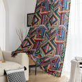 Vibrant geometric bohemian curtain with bold multicolor diamond patterns, featuring intricate woven-style designs and colorful tassel trim — ideal for adding a lively, artistic statement to any room décor.