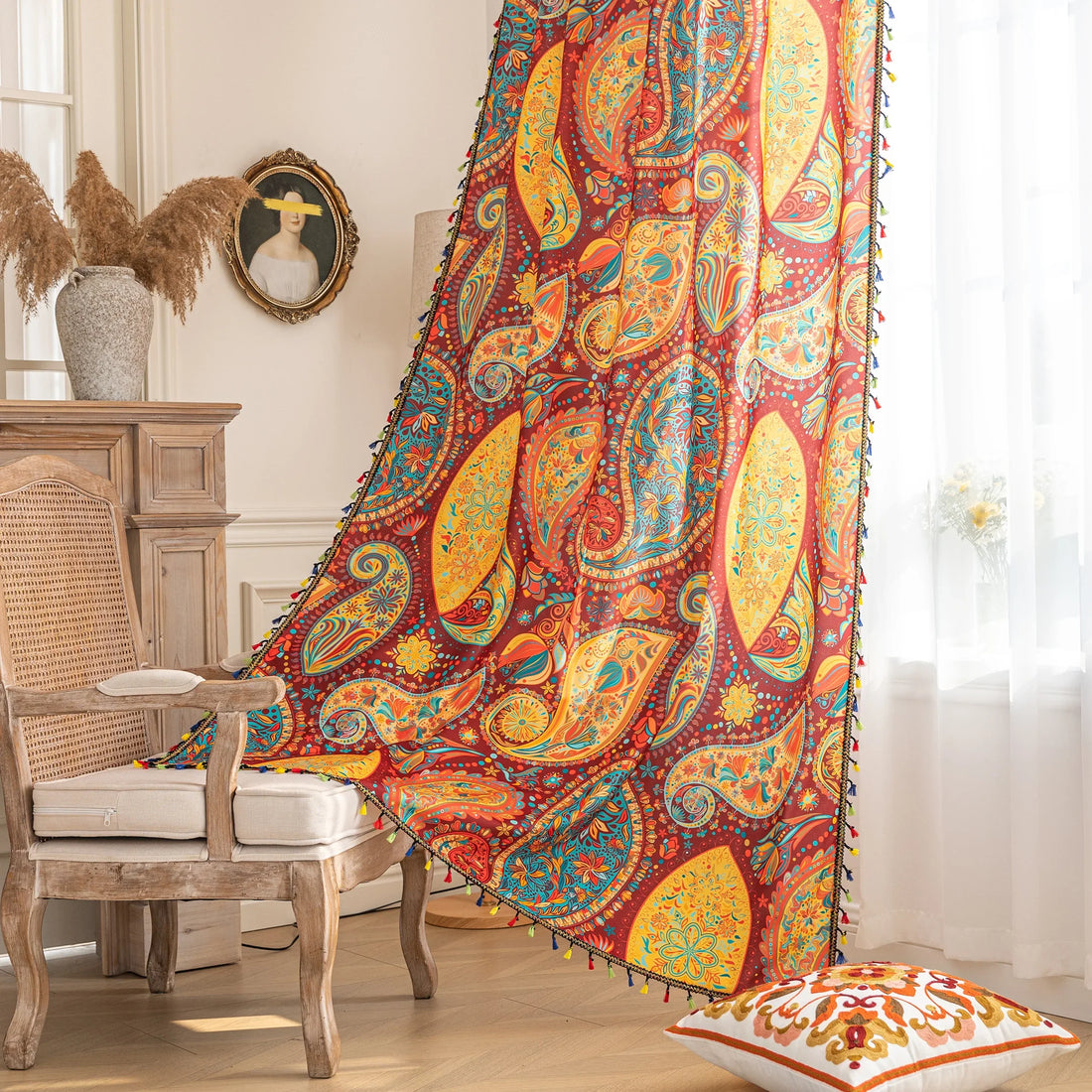 Vibrant bohemian curtain with an intricate paisley pattern in rich red, golden yellow, turquoise, and orange tones, accented with colorful tassel trim — perfect for adding a warm, artistic, and eclectic charm to your living room or bedroom décor.