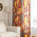Vibrant bohemian curtain with an intricate paisley pattern in rich red, golden yellow, turquoise, and orange tones, accented with colorful tassel trim — perfect for adding a warm, artistic, and eclectic charm to your living room or bedroom décor.