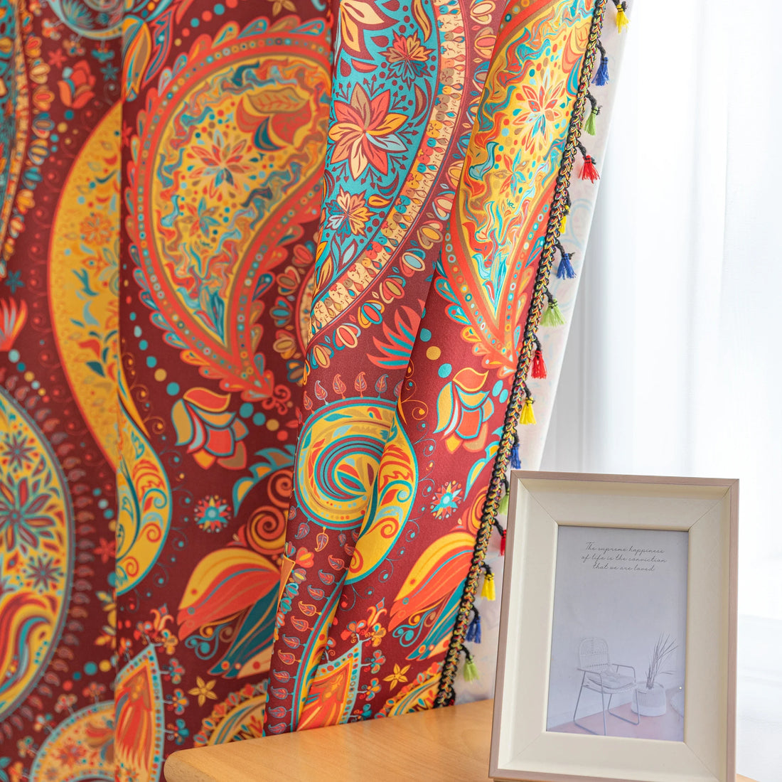 Vibrant bohemian curtain with an intricate paisley pattern in rich red, golden yellow, turquoise, and orange tones, accented with colorful tassel trim — perfect for adding a warm, artistic, and eclectic charm to your living room or bedroom décor.