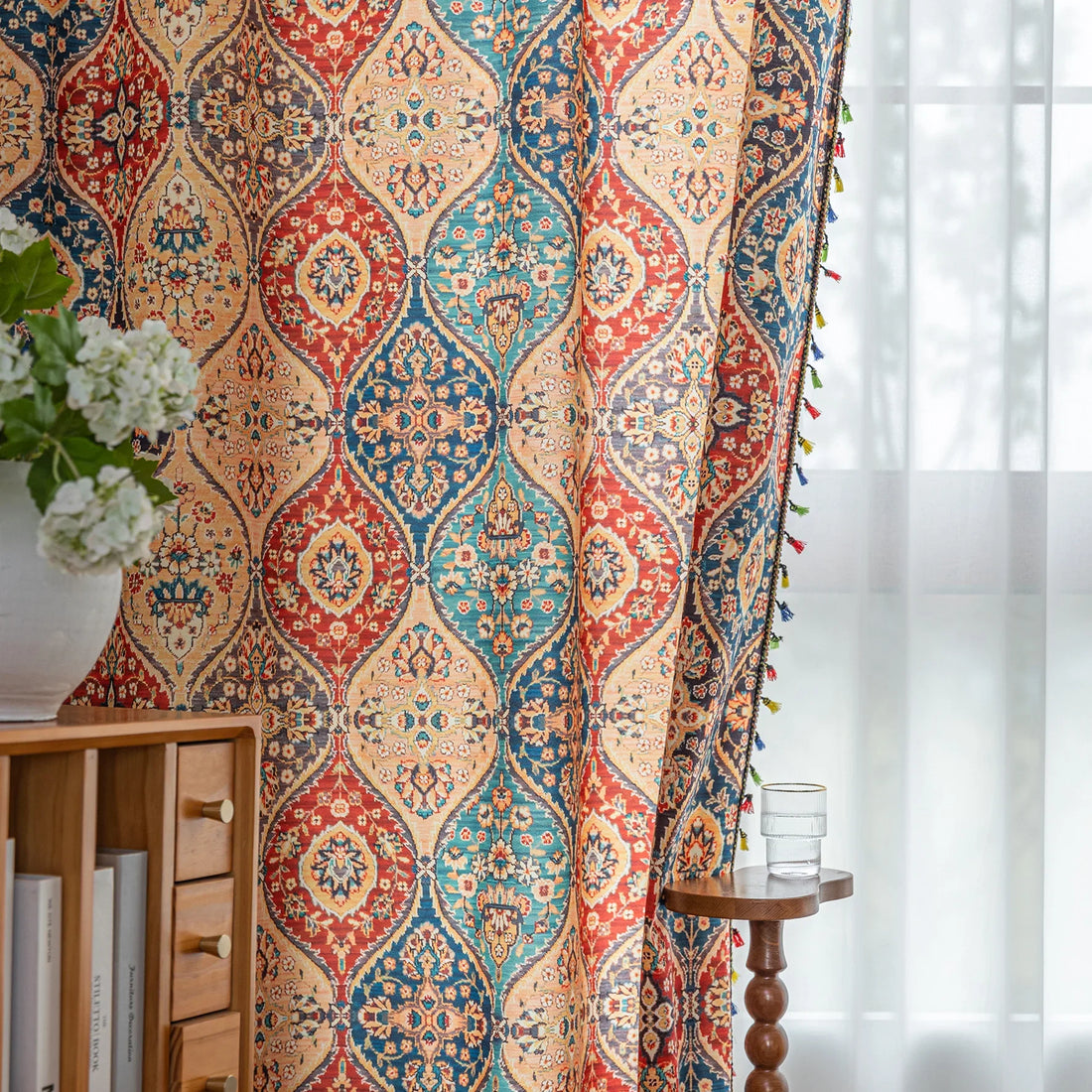 Elegant bohemian curtain featuring a Moroccan-inspired teardrop pattern in warm beige, deep red, and rich blue tones, adorned with intricate floral details and colorful tassel trim — perfect for adding warmth, texture, and global charm to any living space.