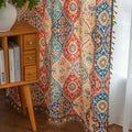 Elegant bohemian curtain featuring a Moroccan-inspired teardrop pattern in warm beige, deep red, and rich blue tones, adorned with intricate floral details and colorful tassel trim — perfect for adding warmth, texture, and global charm to any living space.