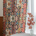 Colorful bohemian curtain with intricate tribal geometric patterns in rich earthy tones of red, beige, turquoise, and gold, accented with multicolor tassels — a perfect choice to add warmth, texture, and global-inspired charm to any room décor.
