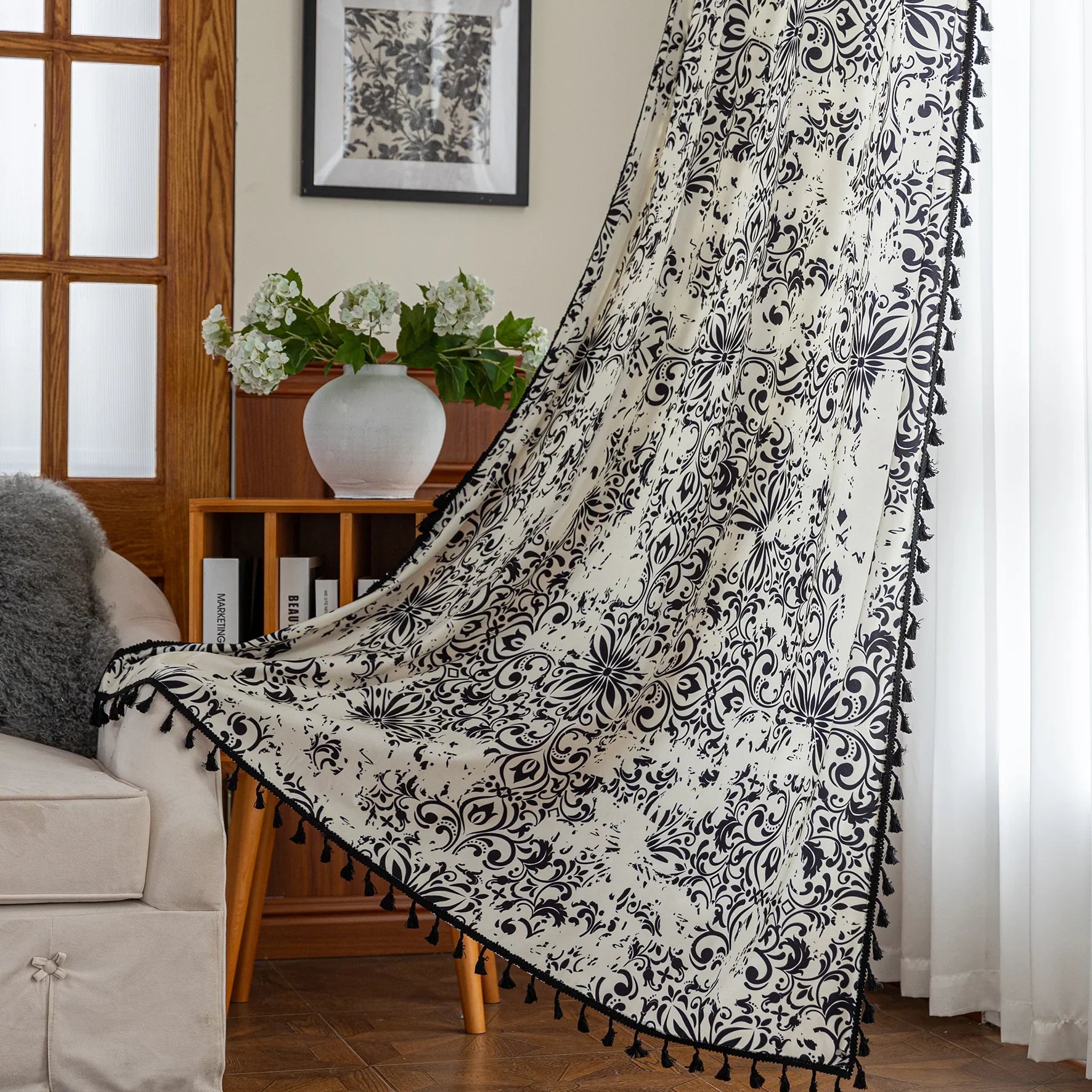 Elegant black and white curtain featuring intricate floral and damask-inspired patterns on a cream background, beautifully finished with matching black tassel trim — perfect for adding timeless sophistication and classic charm to any room décor.