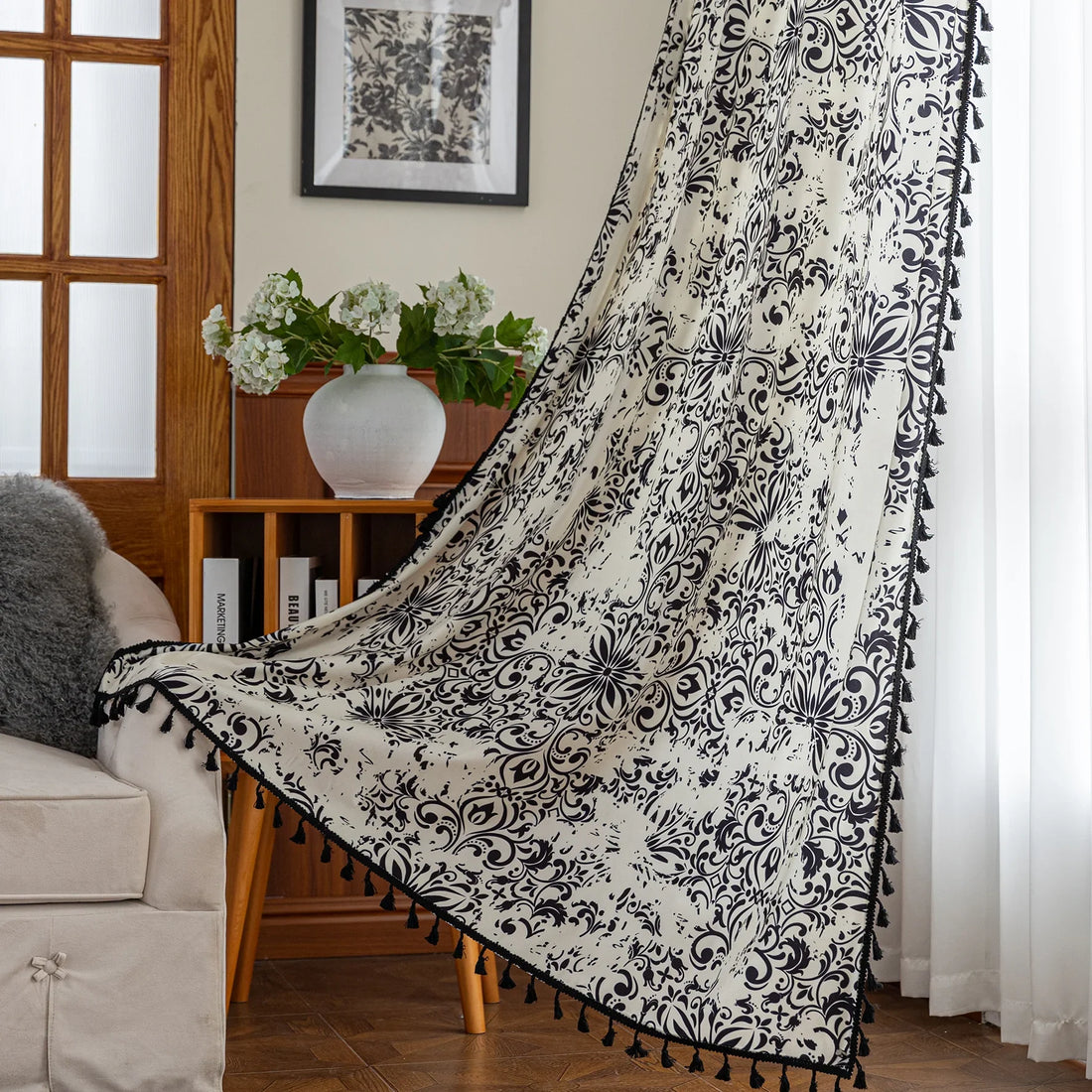 Elegant black and white curtain featuring intricate floral and damask-inspired patterns on a cream background, beautifully finished with matching black tassel trim — perfect for adding timeless sophistication and classic charm to any room décor.