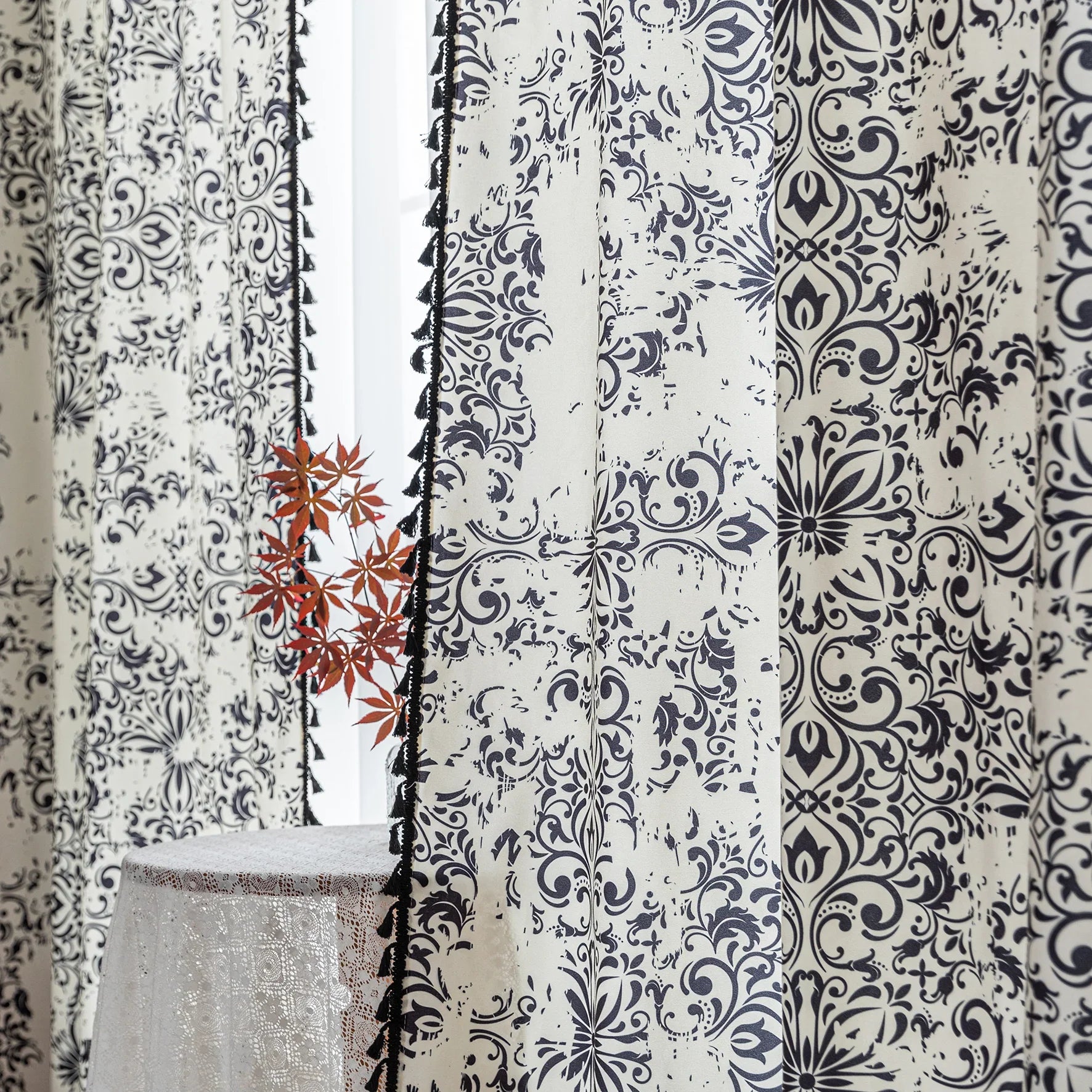 Elegant black and white curtain featuring intricate floral and damask-inspired patterns on a cream background, beautifully finished with matching black tassel trim — perfect for adding timeless sophistication and classic charm to any room décor.