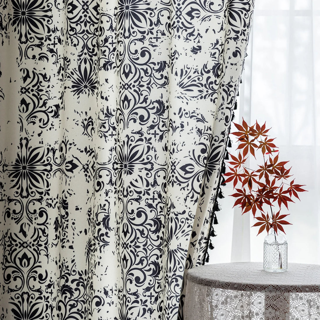 Elegant black and white curtain featuring intricate floral and damask-inspired patterns on a cream background, beautifully finished with matching black tassel trim — perfect for adding timeless sophistication and classic charm to any room décor.