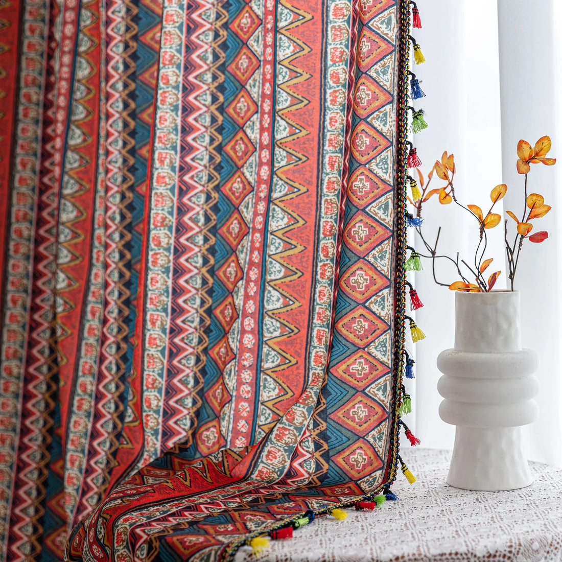 Bold tribal-inspired curtain with vibrant red, blue, and yellow geometric diamond patterns, accented by colorful tassel trim — perfect for adding a touch of ethnic charm and warmth to any bohemian or eclectic home décor.