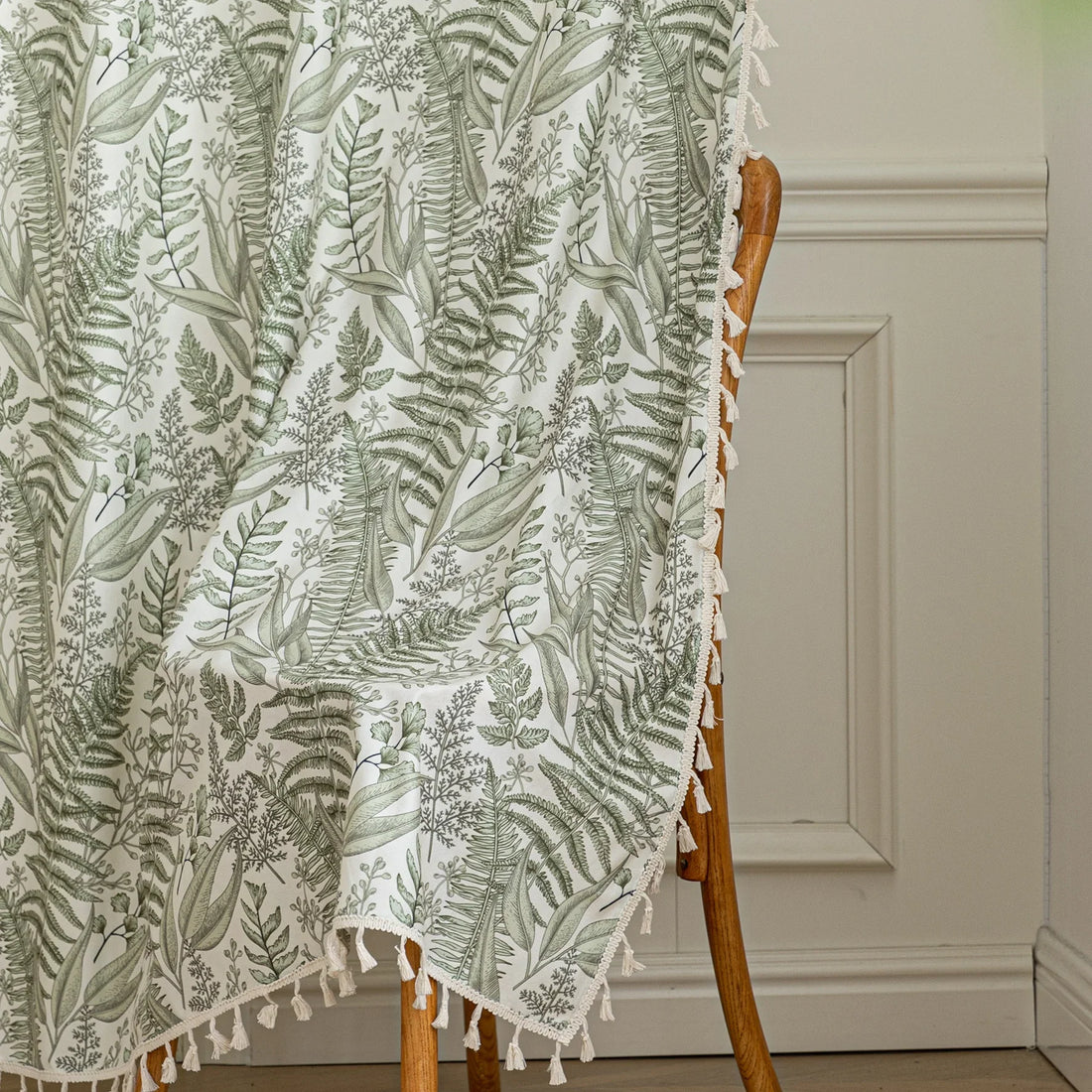Botanical-themed curtain featuring lush green fern and leaf prints on a soft beige background, accented with delicate tassel trim — perfect for bringing a fresh, natural, and calming touch to any living space.