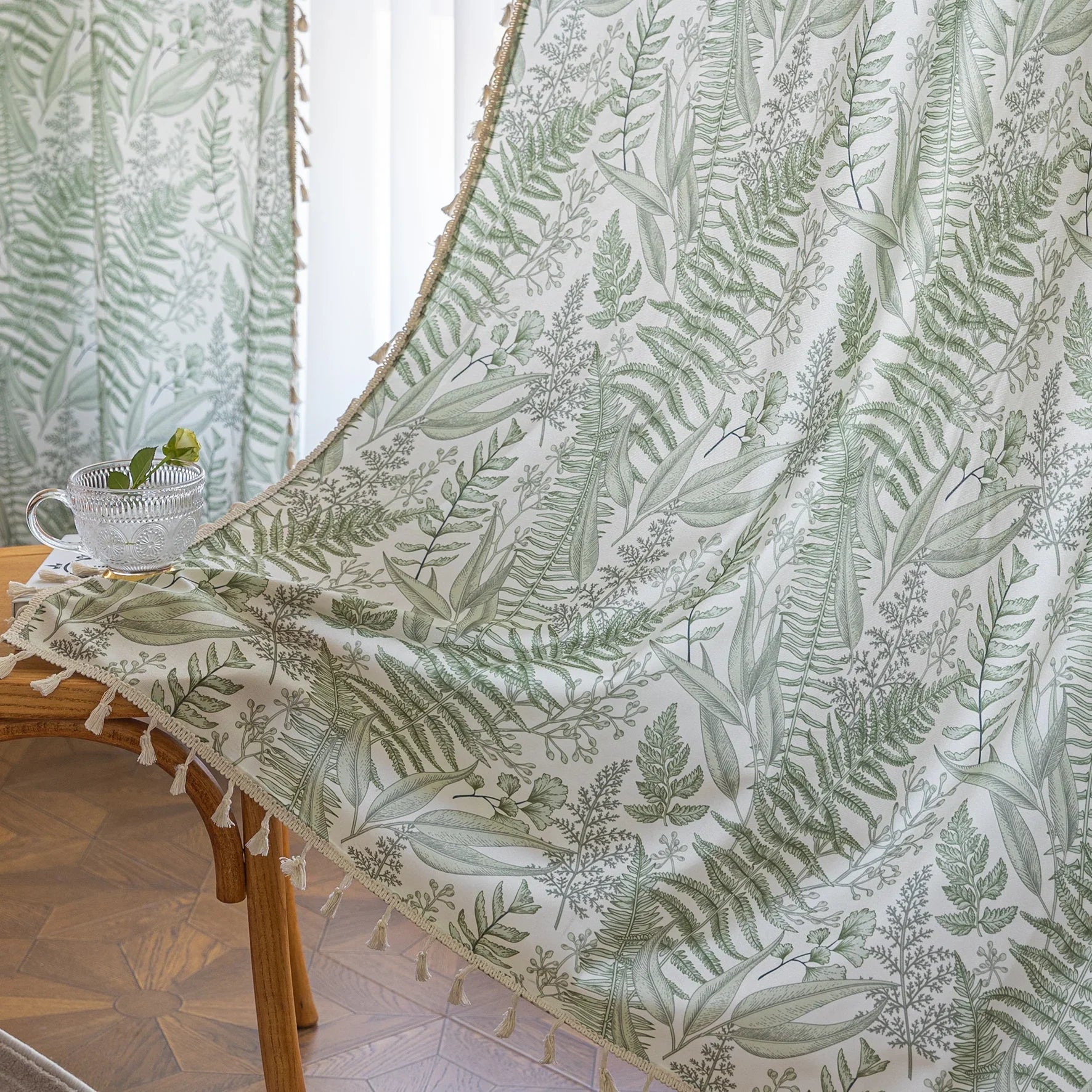 Botanical-themed curtain featuring lush green fern and leaf prints on a soft beige background, accented with delicate tassel trim — perfect for bringing a fresh, natural, and calming touch to any living space.